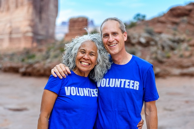 a man and woman wearing blue volunteer shirts and smiling